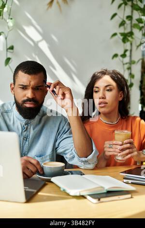 Una coppia afroamericana lavora insieme come freelance mentre si diverte l'una con l'altra. Foto Stock