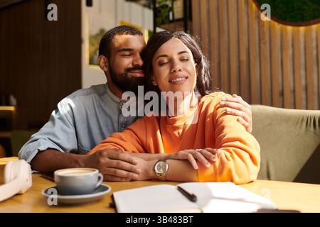 Una felice coppia afroamericana condivide un momento tenero insieme in un bar. Foto Stock