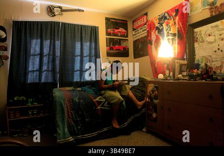 29 giugno 2015 - St. Petersburg, Florida, Stati Uniti - DIRK SHADD | Times .Black Students Achievement gap project:.Ivan Rivera-Otero lavora sui suoi schizzi e disegni mentre si siede sul suo letto nel suo angolo della loro casa mobile nel parco mobile Sun Village di largo. (foto scattata il 06/29/15). RIASSUNTO DELLA STORIA: La famiglia di Ivan viveva vicino a tutti l'ospedale pediatrico in modo che il suo fratello disabile Derrick potesse ottenere cure mediche regolari. Ma dopo che Ivan era stato vittima di bullismo alla Campbell Park Elementary School, sua madre ha dovuto scegliere tra l'educazione di un figlio e la salute di un figlio. Dopo essersi sentiti a rischio a scuola, t Foto Stock