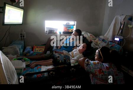 29 giugno 2015 - St. Petersburg, Florida, Stati Uniti - DIRK SHADD | Times.Black Students Achievement gap project:.Ivan Rivera-Otero si arrampica a letto con il fratellino Derrick per guardare la televisione con lui e leggergli con lui mentre la mamma Ermarie Otero viene al letto della loro casa mobile nel parco di casa mobile Sun Village di largo. (Foto scattata il 06/29/15).STORIA SOMMARIO: La famiglia di Ivan viveva vicino all'ospedale pediatrico in modo che il suo fratello disabile Derrick potesse ricevere cure mediche regolari. Ma dopo che Ivan e' stato vittima di bullismo alla Campbell Park Elementary School, sua madre ha dovuto scegliere tra Foto Stock
