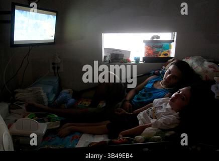 29 giugno 2015 - St. Petersburg, Florida, Stati Uniti - DIRK SHADD | Times.Black Students Achievement gap project:.Ivan Rivera-Otero si arrampica a letto con il fratellino Derrick per guardare la televisione con lui e leggergli nella loro casa mobile nel parco mobile Sun Village di largo. (Foto scattata il 06/29/15).STORIA SOMMARIO: La famiglia di Ivan viveva vicino a tutti l'ospedale pediatrico in modo che il suo fratello malato Derrick potesse ottenere cure mediche regolari. Ma dopo che Ivan era stato vittima di bullismo alla Campbell Park Elementary School, sua madre ha dovuto scegliere tra l'educazione di un figlio e la salute di un figlio. Dopo essermi sentito insicuro Foto Stock