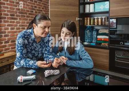 La famiglia in cucina ascolta la radio alimentata a batteria in caso di calamità naturali o interruzioni di corrente Foto Stock