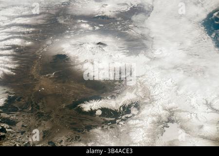28 luglio 2015 - Kamchatka, Russia - questa fotografia del maggio 2015, scattata da un astronauta a a bordo della stazione spaziale Internazionale, evidenzia una delle regioni vulcaniche più attive della Terra: La penisola di Kamchatka nell'estremo est della Russia. I tre vulcani più grandi visibili al centro dell'immagine includono Kliuchevskoy, Bezymianny e Ushkovsky. Klyuchevskoy è il vulcano più attivo, con dati geologici, storici e osservativi che indicano che non vi sono grandi periodi di quiete da quando il vulcano si è formato circa 6.000 anni fa. (Immagine di credito: © NASA/ZUMAPRESS.com) Foto Stock