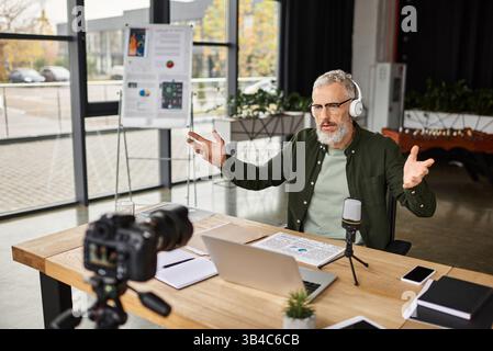 Un uomo professionista si impegna attivamente in una discussione virtuale, utilizzando un notebook durante i gesti. Foto Stock