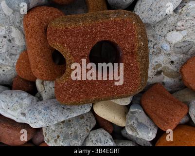 Onde morbide che si infrangono su pietre arrotondate dell'Ontario create con vecchi materiali da costruzione. Bellezza nella bonifica. Foto Stock