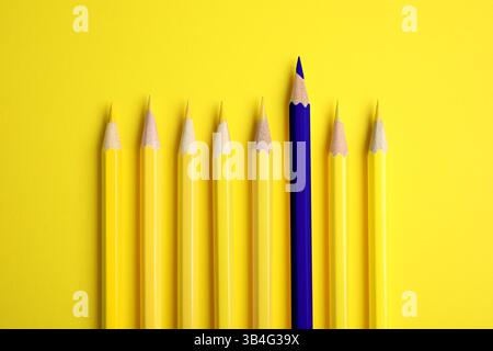 Individualità, unicità, diversa. Matita blu tra quelle gialle su sfondo luminoso, vista dall'alto Foto Stock