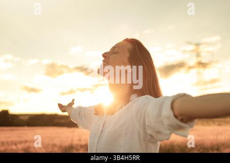 Donna libera e ispirata nella splendida natura del tramonto. Foto Stock