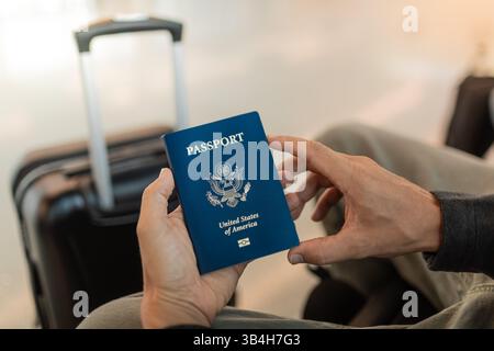 Uomini con passaporto americano in attesa del volo in aeroporto. Foto Stock
