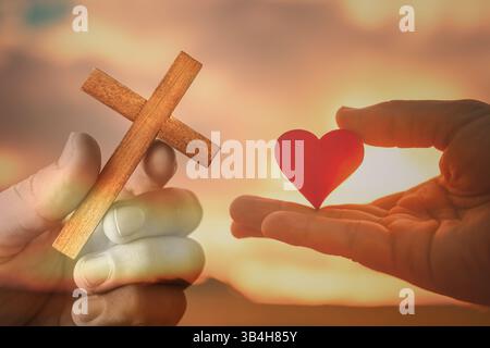 Mano che tiene la croce. Simbolo religioso del perdono, della salvezza, dell'amore e del concetto di speranza Foto Stock