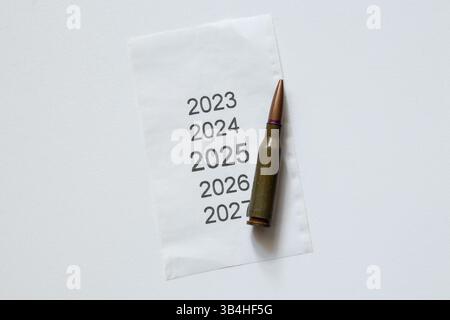 Il proiettile si trova su carta con anni stampati dal 2023 al 2027 su sfondo bianco, piani per il futuro Foto Stock
