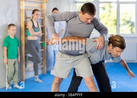 L'uomo in palestra esegue elementi di base del sistema di autodifesa krav maga. Foto Stock