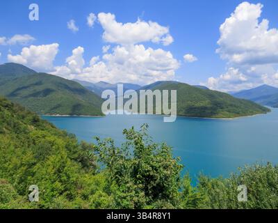 Panorama del bacino idrico di Zhinvali con acqua turchese, circondato dalle pittoresche montagne del Caucaso sulla strada militare georgiana. Diga idroelettrica di Arag Foto Stock