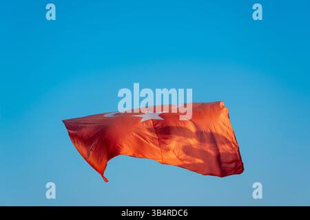 Bandiera turca che sventola nel cielo blu in una giornata di sole Foto Stock
