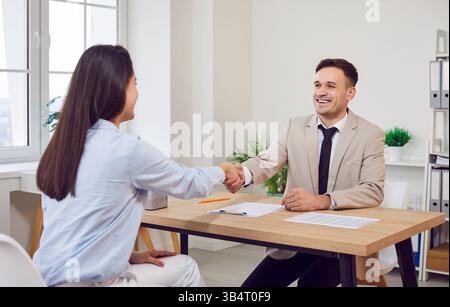 Sorridere due uomini d'affari, uomini felici, imprenditori donne che stringono la mano dopo aver discusso Foto Stock