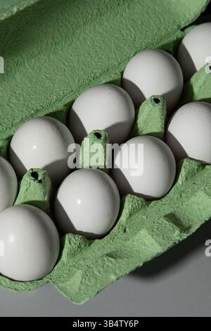 Scatola di uovo verde di cartone su uno sfondo grigio, un sacco di uova sono nella scatola. Foto Stock