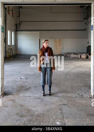 Ritratti donna di genere, che indossa la moda maschile all'interno di un ambiente industriale. Tilburg, Paesi Bassi. MR=SÌ Foto Stock