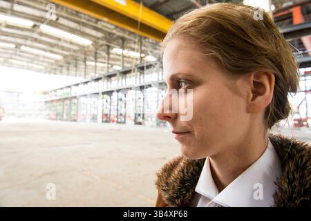 Ritratti donna di genere, che indossa la moda maschile all'interno di un ambiente industriale. Tilburg, Paesi Bassi. MR=SÌ Foto Stock