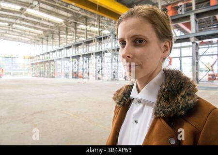 Ritratti donna di genere, che indossa la moda maschile all'interno di un ambiente industriale. Tilburg, Paesi Bassi. MR=SÌ Foto Stock