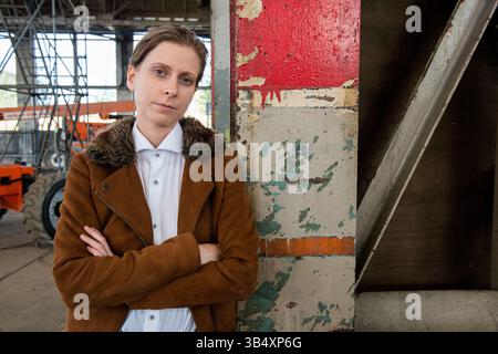 Ritratti donna di genere, che indossa la moda maschile all'interno di un ambiente industriale. Tilburg, Paesi Bassi. MR=SÌ Foto Stock