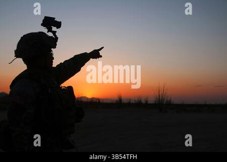 Soldato degli Stati Uniti dal quartier generale e dal quartier generale distaccamento, 759th Military Police Battalion, assegnato alla Joint Task Force - Southern Border regola i dispositivi di osservazione notturna al tramonto mentre conduce addestramento per mantenere la prontezza a Wellton, Ariz., il 18 aprile 2025. Sotto la direzione del Northern Command degli Stati Uniti, la Joint Task Force – Southern Border allinea gli sforzi per sigillare il confine meridionale e respingere le attività illegali ed è responsabile di operazioni su larga scala, agili e di tutti i domini, che consentiranno operazioni DoD più efficaci ed efficienti. (Foto dell'esercito statunitense del 2° tenente Erica Esterly) Foto Stock