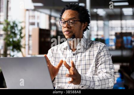 Il General Manager di Black Man si collega con il suo team tramite videochiamata, rivedendo le operazioni aziendali e gli obiettivi strategici. Utilizzare la comunicazione online per consentire un processo decisionale efficiente. Foto Stock