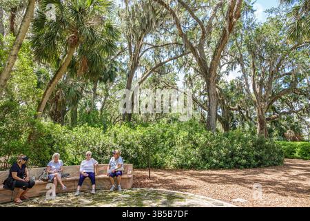 Lake Wales Florida, Bok Tower Gardens, amici donne anziane, panca curva in pietra, area boschiva ombreggiata, querce muschio spagnolo sopra la testa, trop Foto Stock