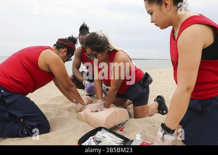 27 maggio 2022: Johanna Leiva, bagnino del Chicago Park District, inginocchiato al centro, dimostra la tecnica della RCP e l'uso di un defibrillatore esterno automatizzato, come altri bagnini guardano a North Avenue Beach a Chicago il 20 maggio 2022. (Immagine di credito: © Jose M. Osorio/Chicago Tribune via ZUMA Press Wire) Foto Stock