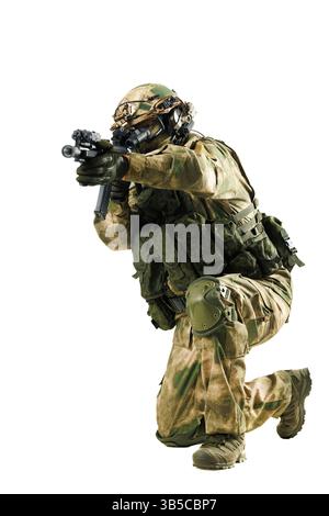Un soldato altamente equipaggiato in equipaggiamento tattico mira e si prepara per un'operazione, mostrando abilità di combattimento. Foto Stock