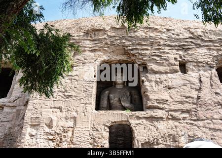 Statua in pietra di Bodhisattva a gambe incrociate nella Grotta 17 delle Grotte di Yungang, Datong, provincia di Shanxi Foto Stock
