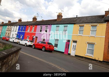 La "Rainbow Square" di Gloucester, con case dai colori vivaci, su Nettleton Road, St Kilda Parade e Station Road, creata dall'artista Tash Frootko. - 1 ma Foto Stock