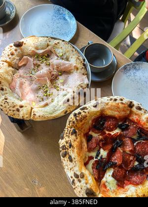 Due pizze classiche con impasto sottile e arioso con salsa di pomodoro fresco e formaggio fuso servite al ristorante Foto Stock