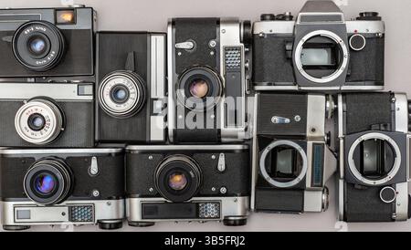 Un assortimento diversificato di vecchie telecamere mostrate insieme, mettendo in risalto i loro design unici e i meccanismi intricati che hanno plasmato la fotografia. Foto Stock