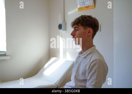 Giovane in clinica in attesa di una vaccinazione Foto Stock