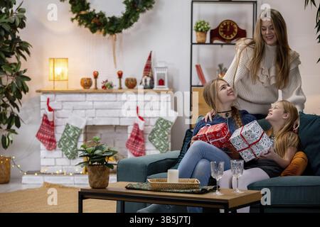 Un'emozionante scena familiare di amore, gioia e risate mentre festeggiano il Natale insieme a regali Foto Stock