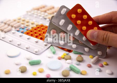 Maschio lato contiene diversi blister colorato sopra pillole e capsule in confezioni di plastica. Global industria farmaceutica per miliardi di dollari all'anno. Ph Foto Stock