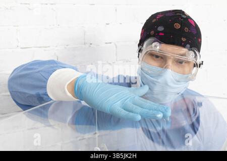 Il dipendente durante la disinfezione cerca di pulire accuratamente ogni centimetro della scatola elettorale per evitare infezioni Foto Stock