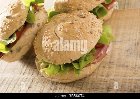 Panini freschi con carne affumicata, formaggio, lattuga e pomodoro con ketchup fatti in casa Foto Stock