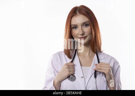 Una donna dottoressa altruista posa con sicurezza con il suo stetoscopio, completamente preparata ad assistere i pazienti bisognosi Foto Stock
