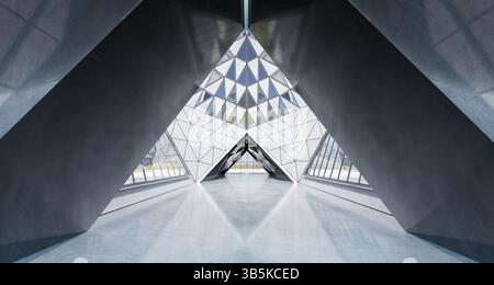 Design contemporaneo a forma di triangolo, interni di un edificio dall'architettura moderna con elementi in vetro, cemento e acciaio. Rendering 3D. Foto Stock