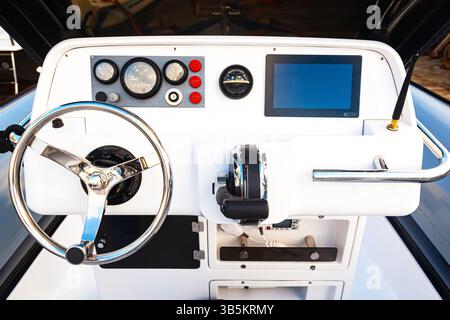 Cabina di controllo dell'imbarcazione con quadro strumenti, volante e stazione radio. Foto Stock