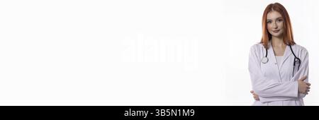 Una dottoressa esperta e sicura di sé vestita con scrub, che mostra uno stetoscopio e indossa un sorriso caldo Foto Stock