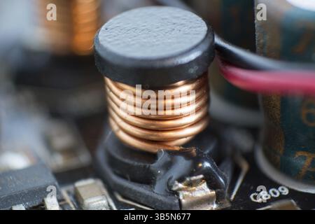 Componenti del computer polverosi. Dettaglio di una scheda madre polverosa. Condensatore elettrolitico e conduttore visibili sulla scheda a circuito stampato. Selectiv Foto Stock