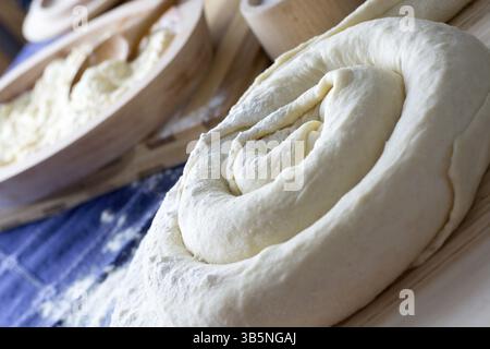 Fabbricazione di formaggio di casa torta o altro tipo di pasticcini o dolci sul piatto di legno. Torta di formaggio pronto per la cottura Foto Stock