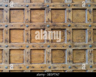 Primo piano di una porta in legno rustico con borchie in metallo Foto Stock
