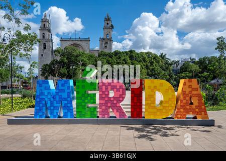 Merida, Yucatan Messico - 01-27-2025: Colorato cartello Merida di fronte allo Zocalo, la cattedrale sullo sfondo nel centro storico di Merida. Foto Stock