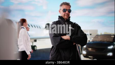 Agente di sicurezza che utilizza Un Walkie-talkie vicino A Un Jet privato. Foto Stock