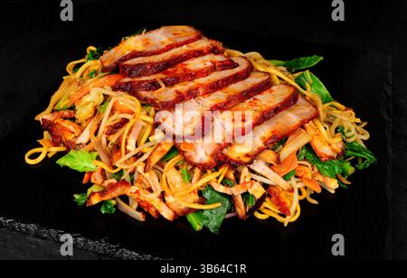 Mein di char cinese con carne di maiale siu con spaghetti fritti in padella e verdure Foto Stock