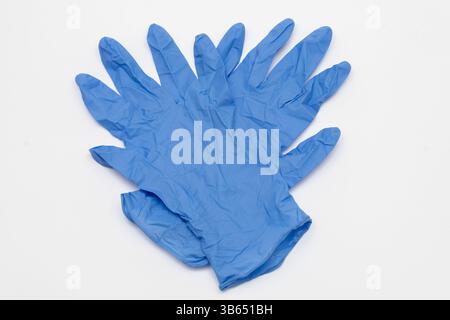 Un paio di guanti in lattice monouso blu su sfondo bianco, simbolo di pulizia e protezione Foto Stock
