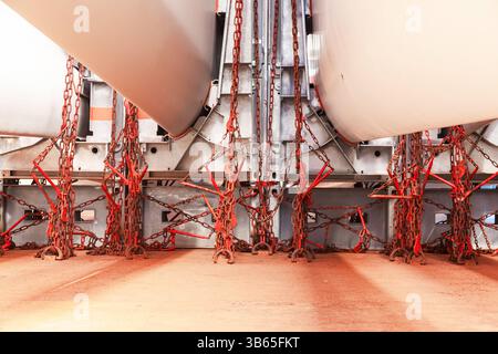 Pale di turbine eoliche poste in appositi dispositivi di fissaggio e incatenate sul ponte della nave. Foto Stock