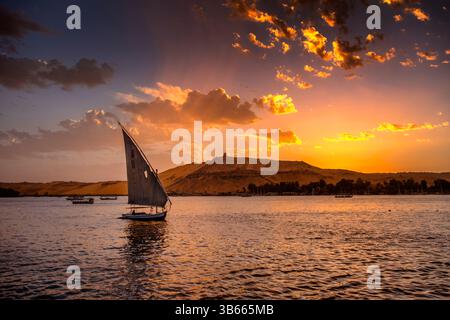 Barca a vela Felucca che scivola sul Nilo al tramonto ad Assuan, Egitto. Foto Stock